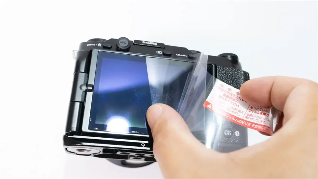 セパレーターを一度に剥がさず、徐々に剝がしながら液晶保護フィルムを張り付けているところ