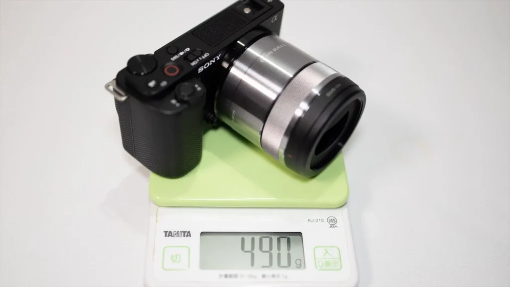 量りの上のSony E 30mm F3.5 MacroとZV-E10 メモリは490g