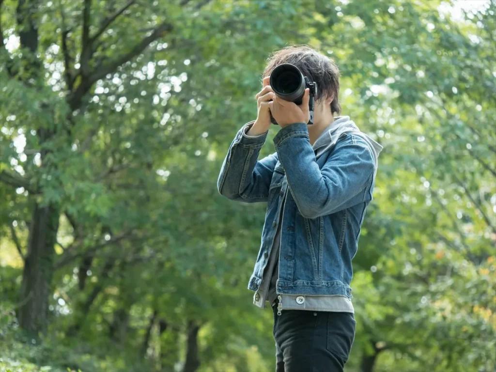 屋外でカメラを構える中級者