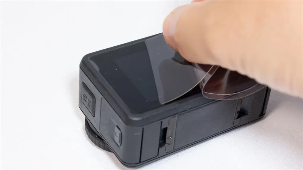Osmo Action 4の背面液晶に保護フィルムを貼り付ける様子