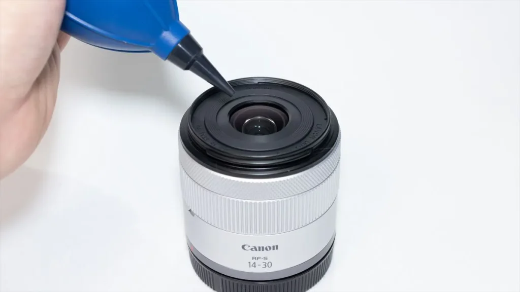 ブロワーでレンズのガラス面のホコリを飛ばす様子