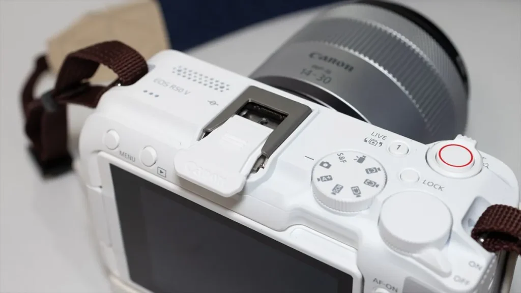 ウインドスクリーン取り付け前にEOS R50 Vのシューカバーを外す様子